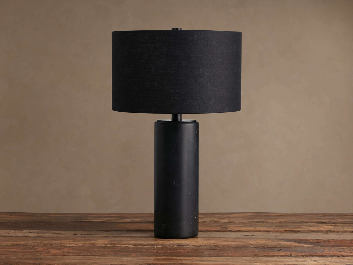 Brixton Table Lamp: Close-up of its cylindrical black marble base with white veining and a thin black metal stem.