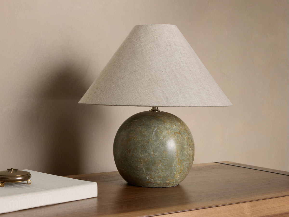 Front view of a table lamp featuring a spherical green marbled base and a light beige linen tapered lampshade.