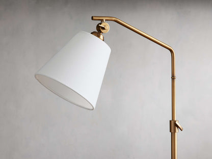 Kellen Table Lamp with antiqued brass adjustable stand and white linen shade, set against a neutral background.