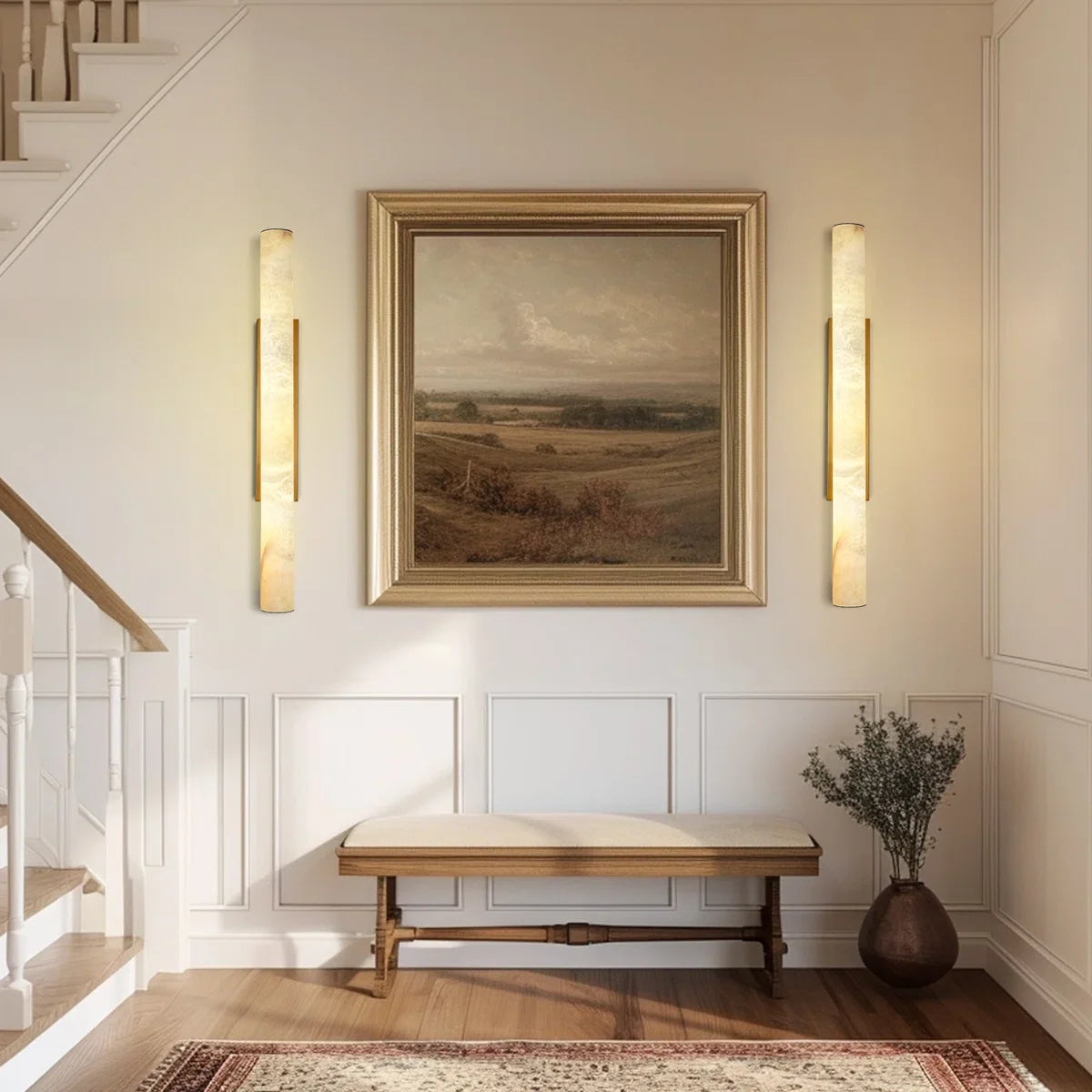 Staircase with wall sconces, a bench, and a framed painting in a home interior.
